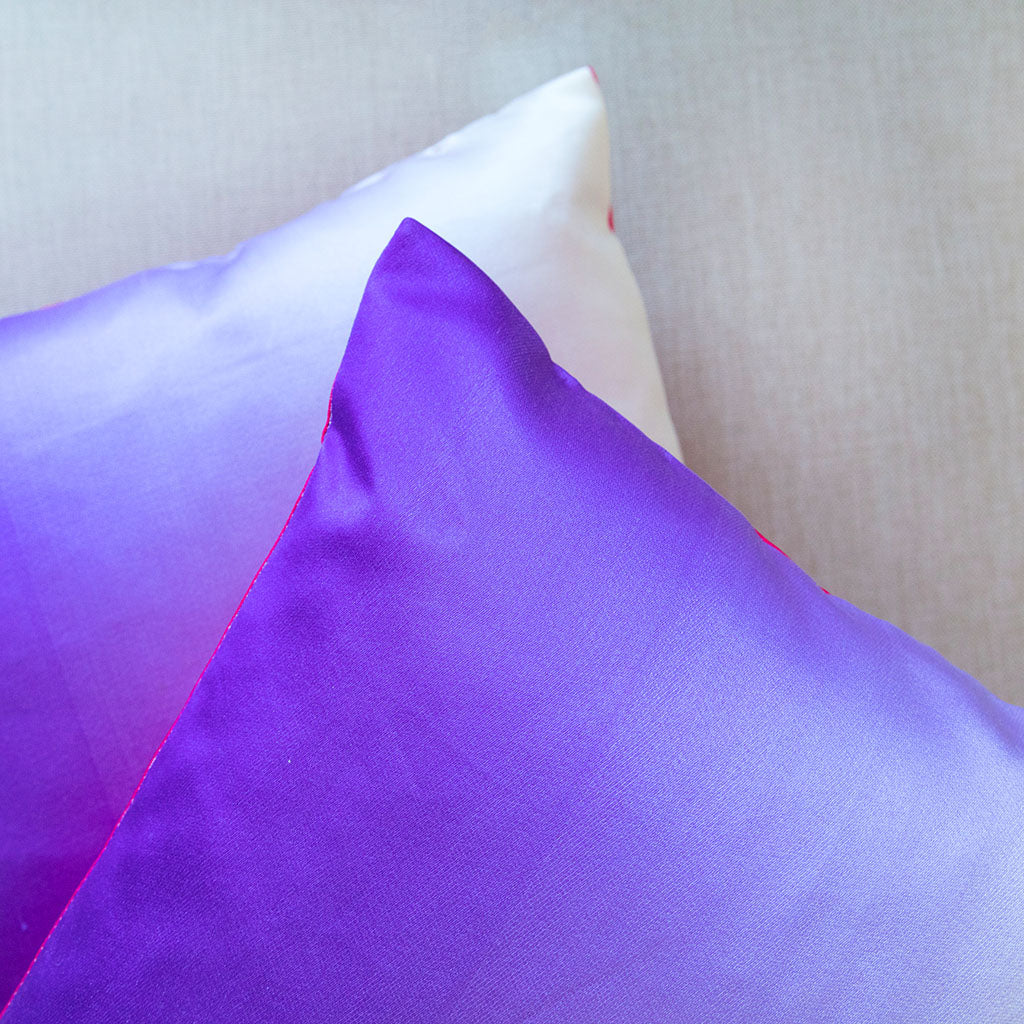 Close-up of the cushion’s pink silk backing, highlighting smooth texture and seamless stitching along the edge.