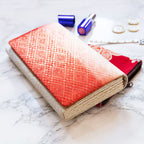 Close-up of the red ombre fabric’s intricate kimono-inspired pattern and textured fold detailing on the clutch front.