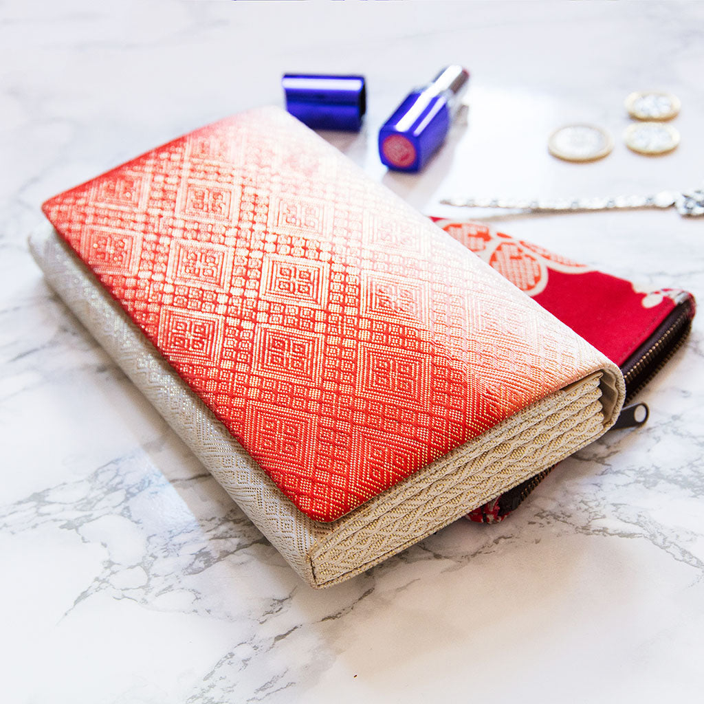 Close-up of the red ombre fabric’s intricate kimono-inspired pattern and textured fold detailing on the clutch front.