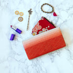 Close-up of the folded clutch’s textured ombre silk fabric featuring intricate kimono-inspired patterns and a gold clasp