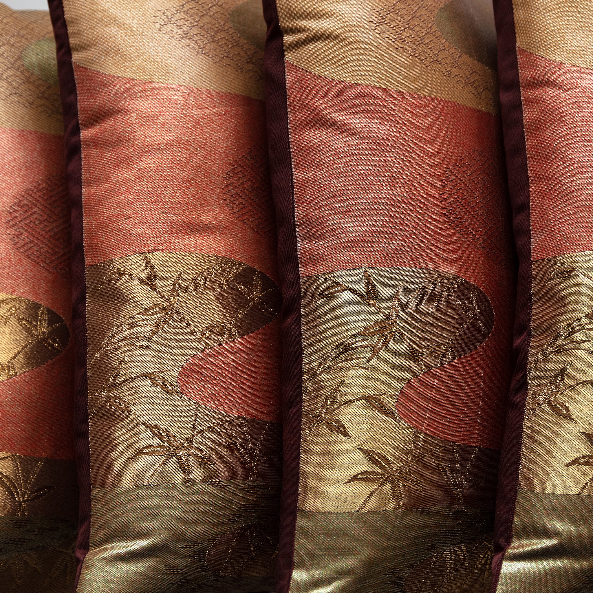 Close-up of intricate bronze obi silk weave showcasing subtle river-inspired patterns and rich textured surface detail.