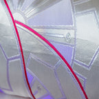 Close-up of pink silk backing showcasing smooth texture and vibrant color contrast with purple obi cushion decorative wheels.