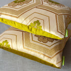 Close-up of the gold geometric pattern and rich velvet texture on the chartreuse Obi Pillow’s corner highlighting intricate
