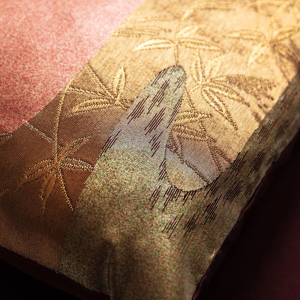 Close-up of the textured bronze silk fabric revealing subtle woven kimono patterns and rich river-inspired color variation.