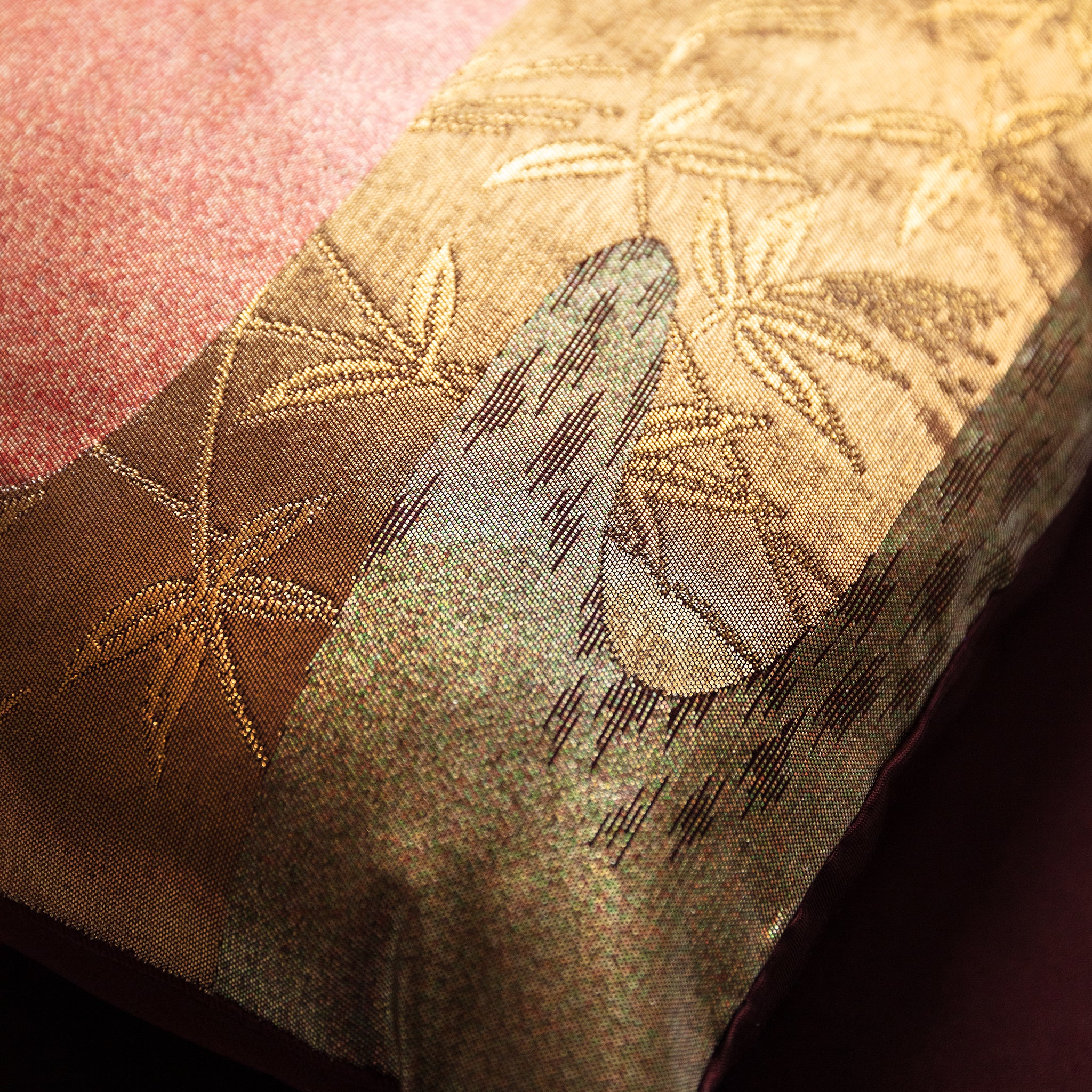 Close-up of the textured bronze silk fabric revealing subtle woven kimono patterns and rich river-inspired color variation.