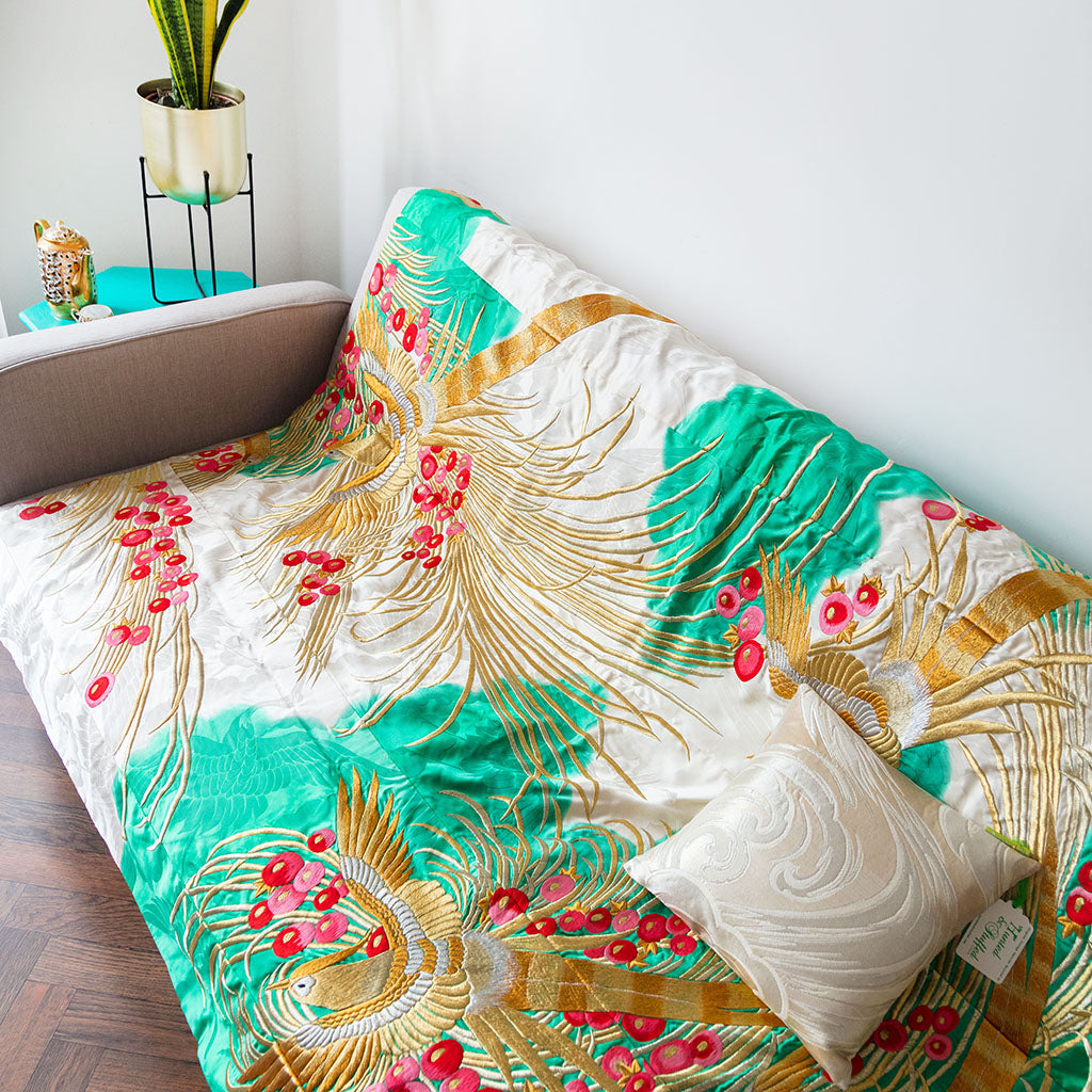 Close-up of intricate gold phoenix embroidery on silk throw blanket border highlighting vintage floral motifs and rich