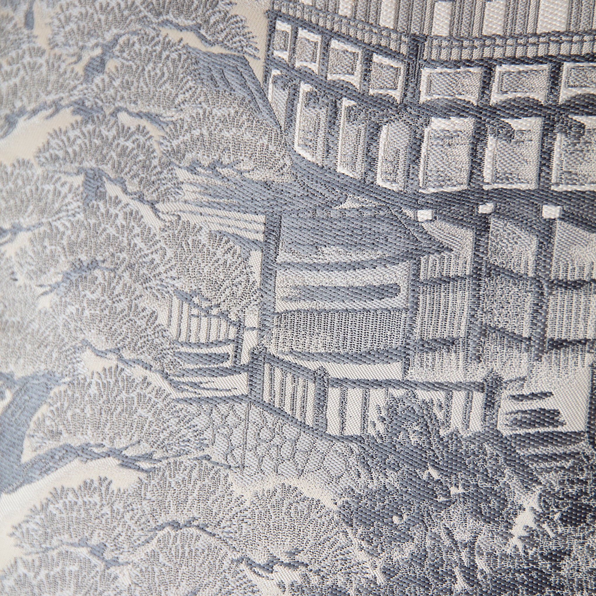 Close-up of textured grey silk cushion fabric with visible stitching and a hint of the shocking pink silk backing at the