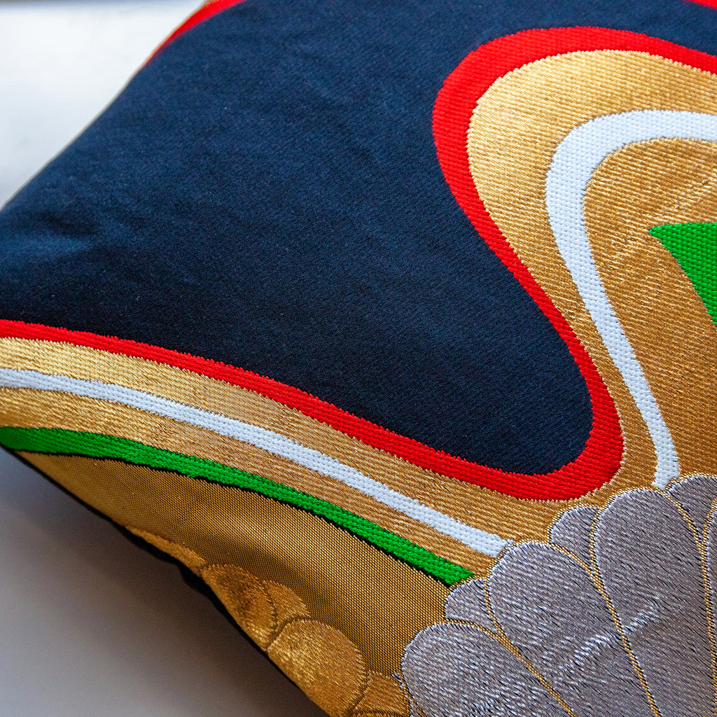 Close-up of the black silk fabric showcasing intricate gold floral embroidery and subtle textured stitching detail.