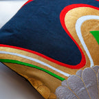 Close-up of the black silk fabric showcasing intricate gold floral embroidery and subtle textured stitching detail.