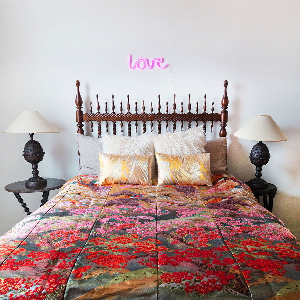 Close-up of vintage floral embroidery details on the silk throw blanket’s edge, highlighting intricate stitching and