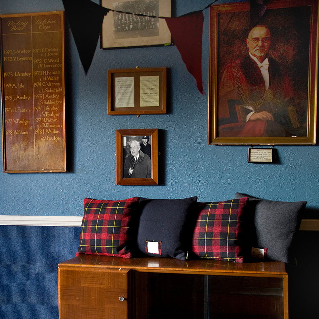 Close-up of navy wool tartan fabric showing intricate pattern weave and subtle vintage texture on the Gannex Ltd Ed THE