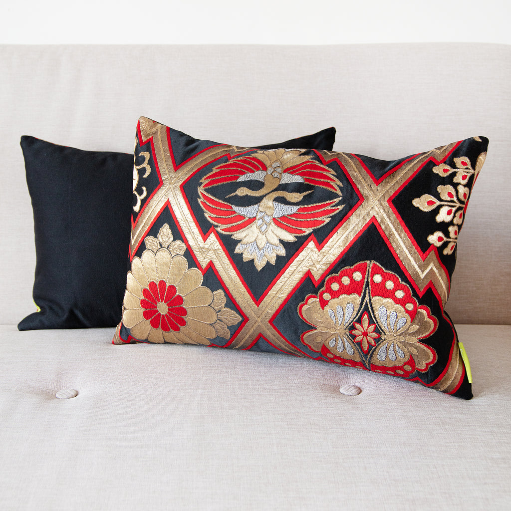 Close-up of the metallic gold and red embroidery detail on the textured black silk fabric of the vintage Japanese