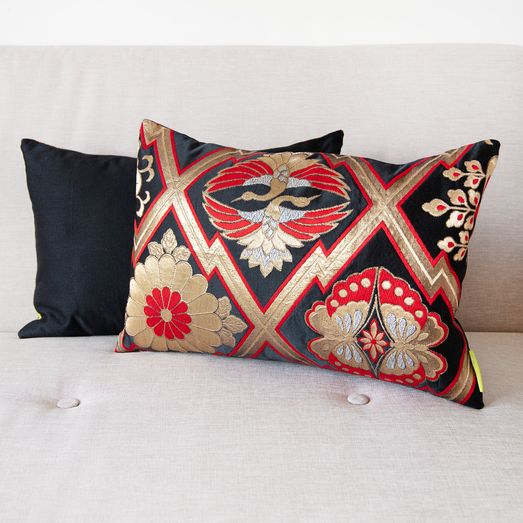 Close-up of the metallic gold and red embroidery detail on the textured black silk fabric of the vintage Japanese