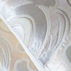 Close-up of intricate silver silk embroidery detail on the white Japanese Wave Cushion fabric edge.