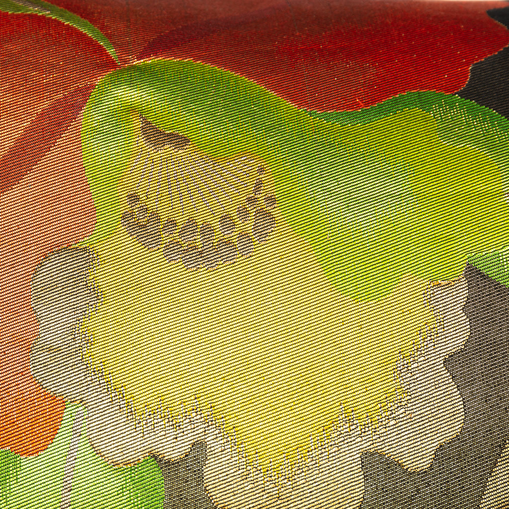 Close-up of red, yellow, gold floral embroidery on black silk fabric showing intricate stitching and vibrant thread details