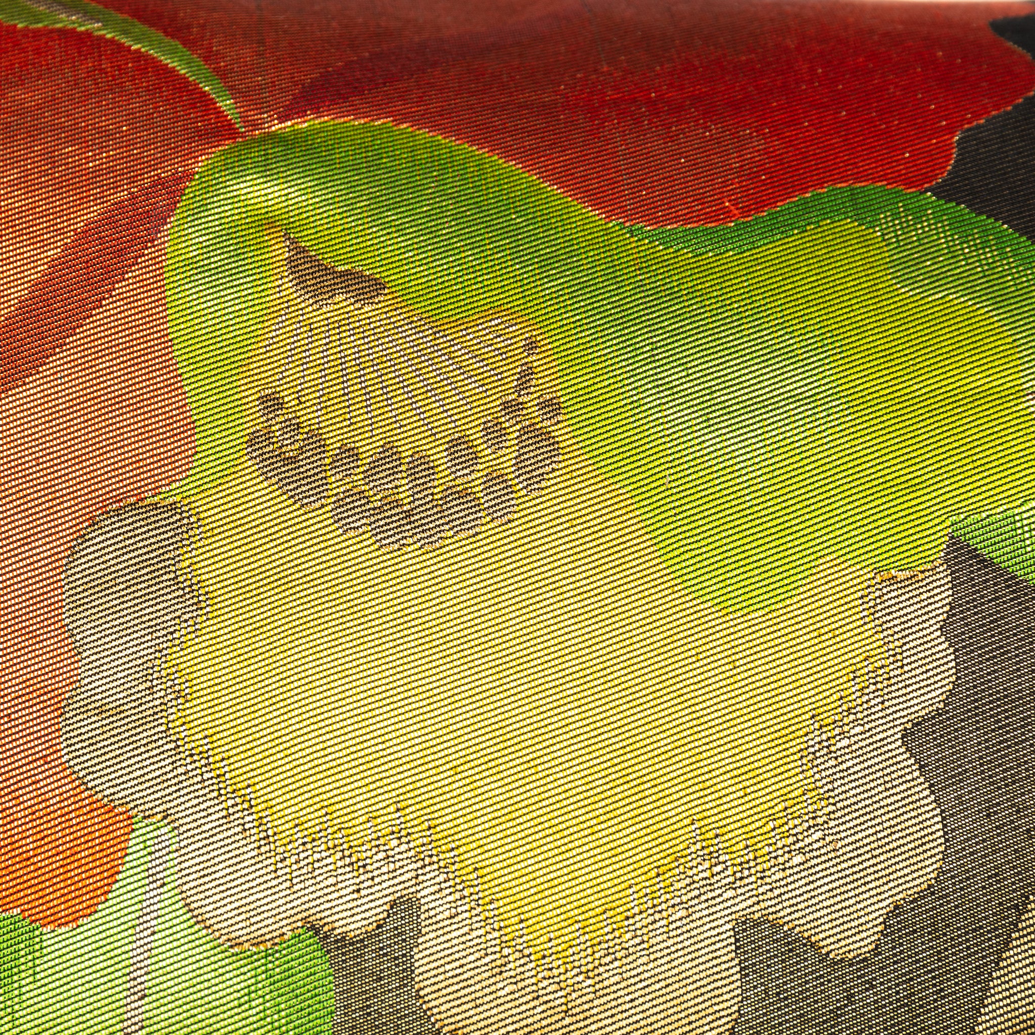 Close-up of red, yellow, gold floral embroidery on black silk fabric showing intricate stitching and vibrant thread details